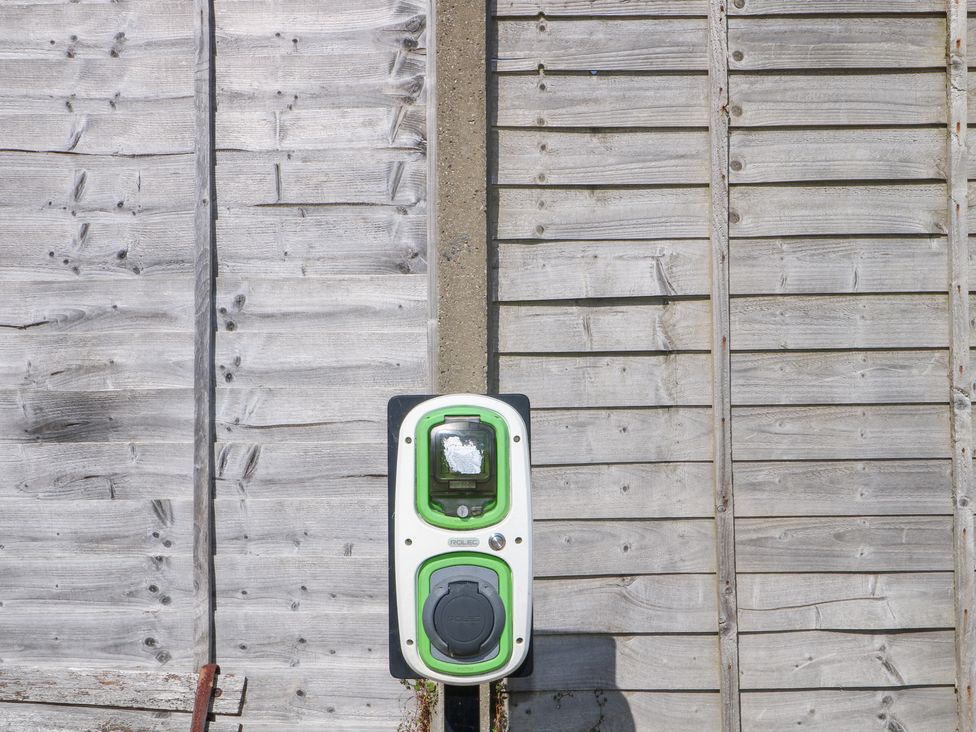 A charging station mounted on a wooden wall at Harbour Road Quirky Beach Railway Carriages Pagham