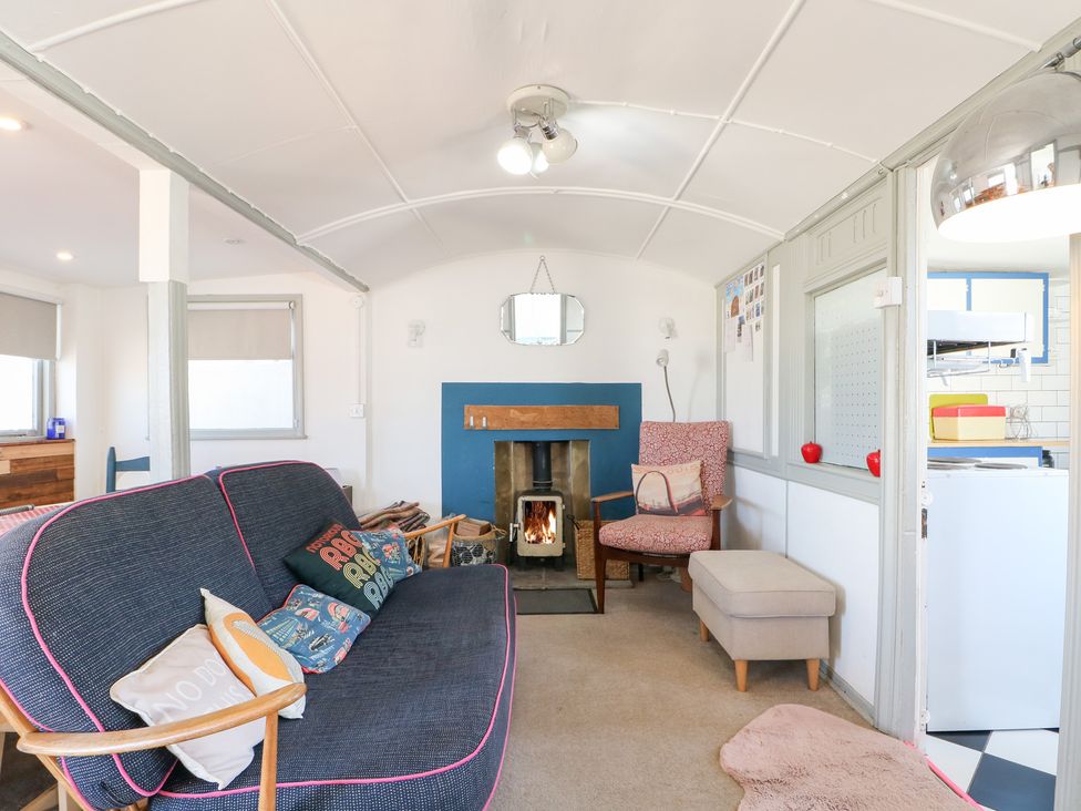 A living room with a fireplace and sofa at Harbour Road Quirky Beach Railway Carriages Pagham