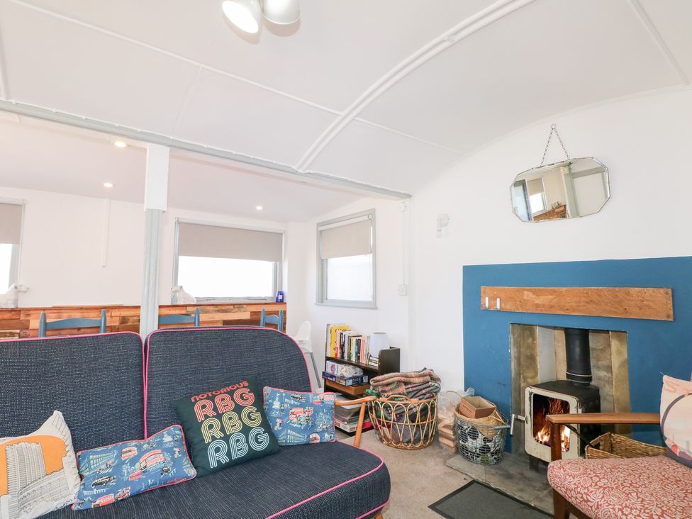 A living room with a sofa and fireplace at Harbour Road Quirky Beach Railway Carriages Pagham
