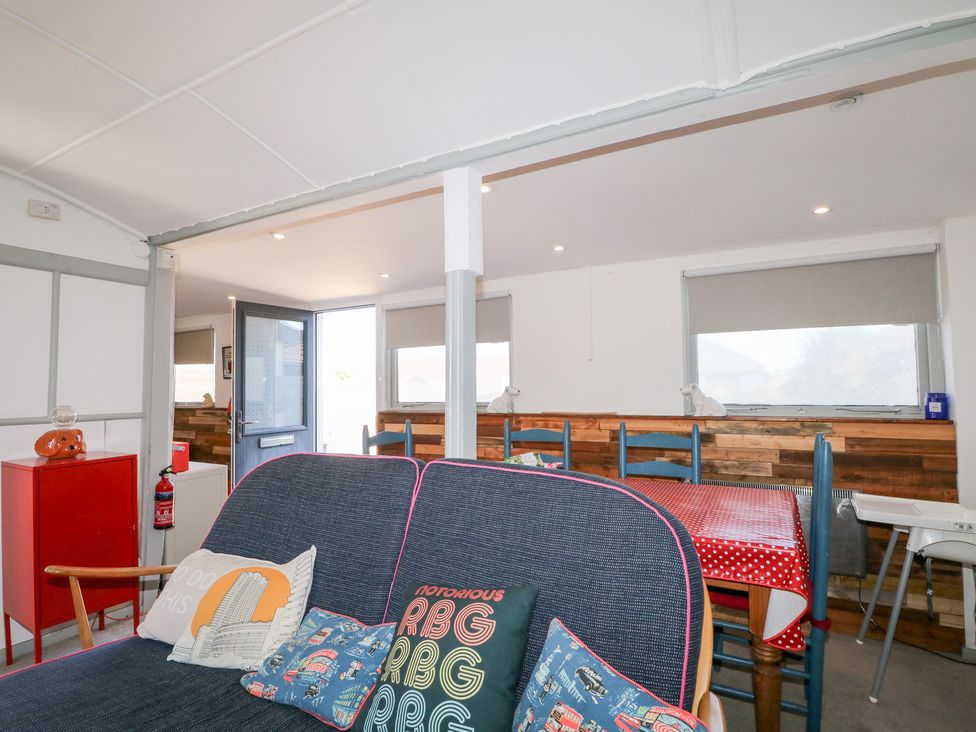 A living room with sofa and dining table at Harbour Road Quirky Beach Railway Carriages Pagham