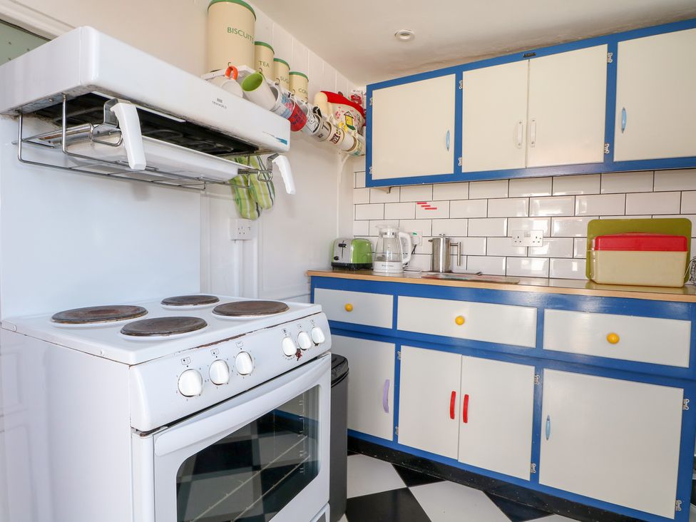 A kitchen with a stove and cabinets at Harbour Road Quirky Beach Railway Carriages Pagham