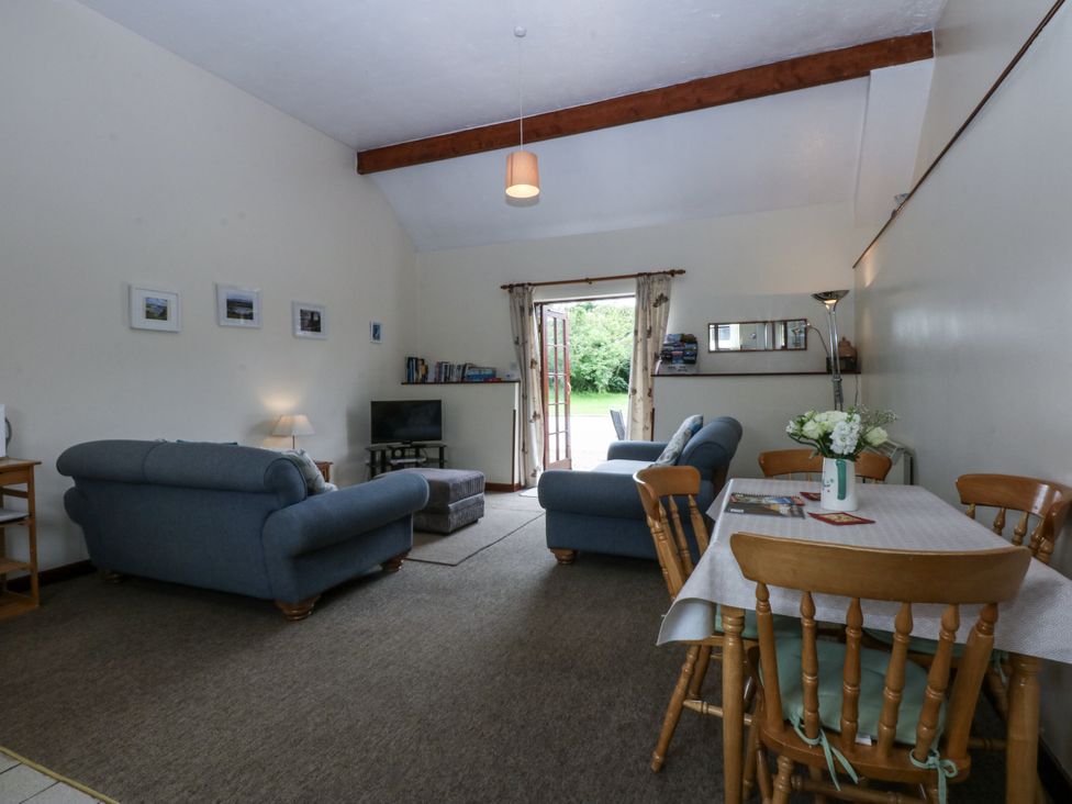 A living room with a sofa and dining table at Florence Cottage in Holyhead