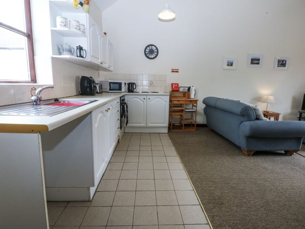 A kitchen with appliances and a seating area at Florence Cottage in Holyhead