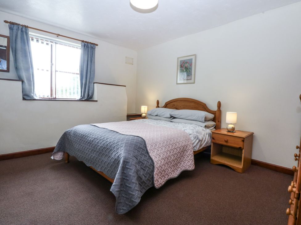 A bedroom with a bed and bedside tables at Florence Cottage Holyhead