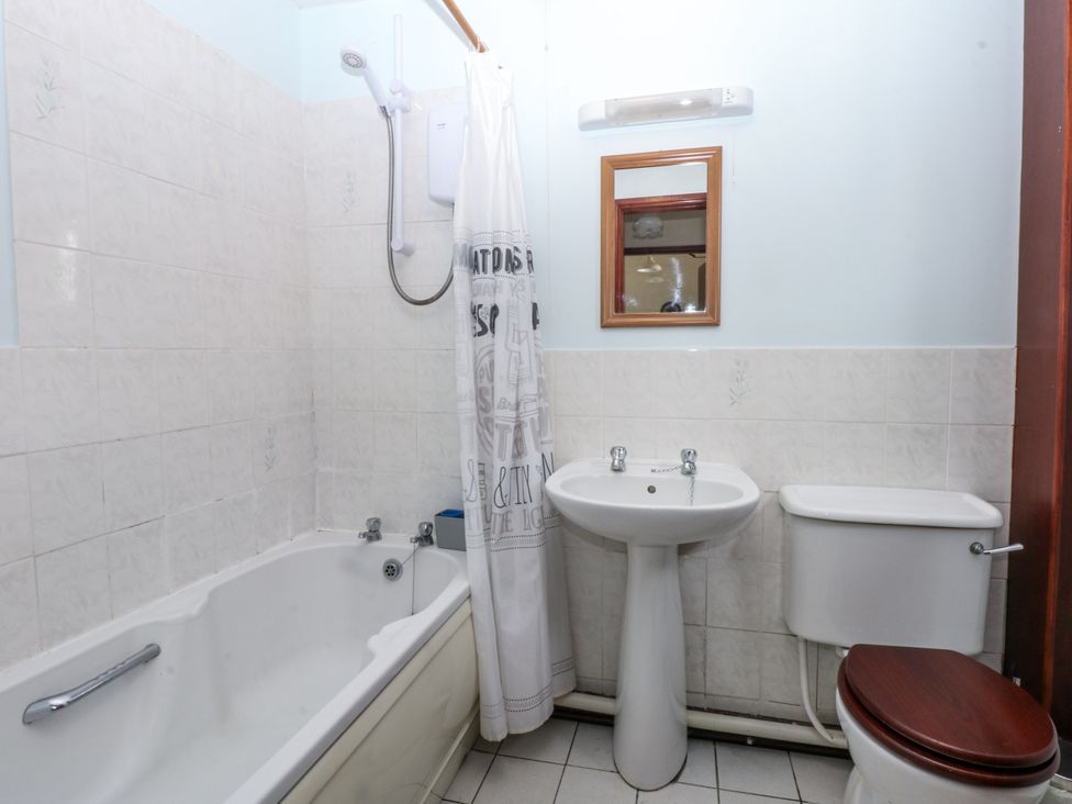 A bathroom with a bathtub, sink, and toilet at Florence Cottage in Holyhead
