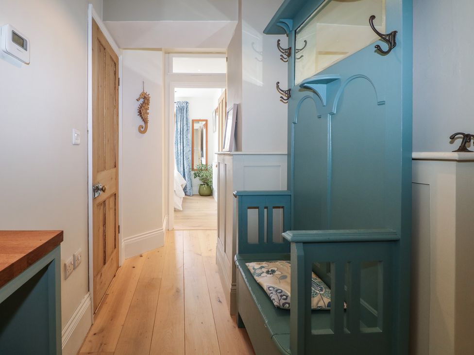 A hallway with a bench and hooks at Lower Floor Flat