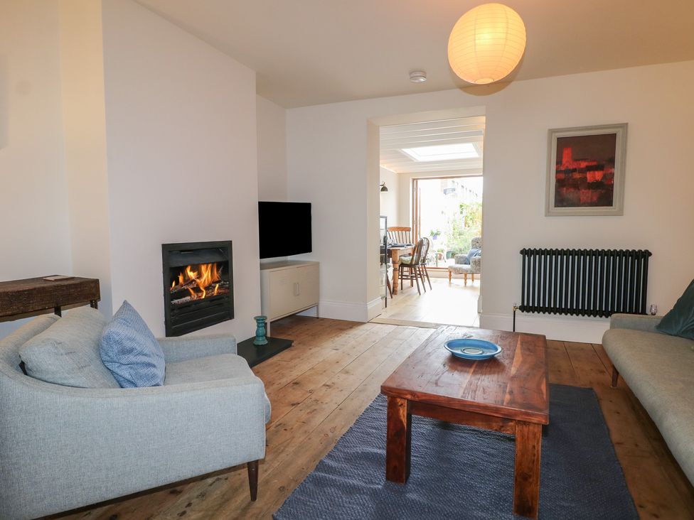 A living room with a sofa, coffee table, and fireplace at Lower Floor Flat
