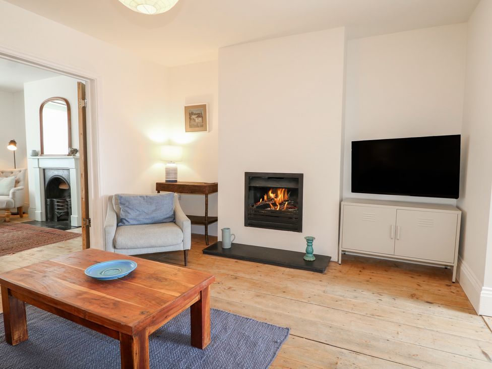 A living room with a fireplace and television at Lower Floor Flat