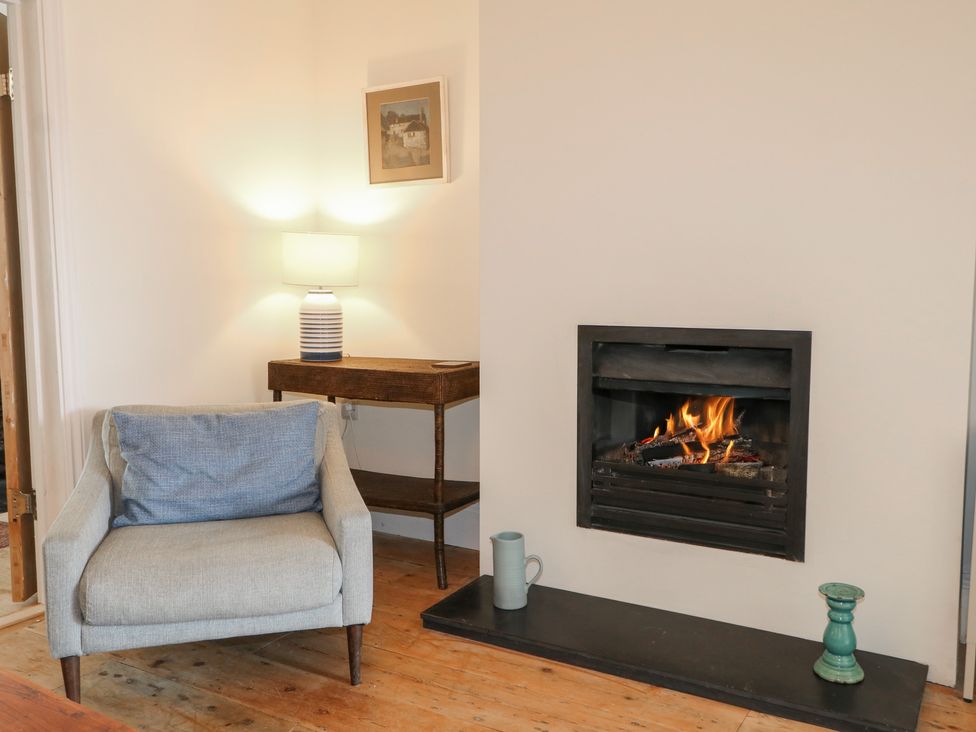 A living room with an armchair and fireplace at Lower Floor Flat 