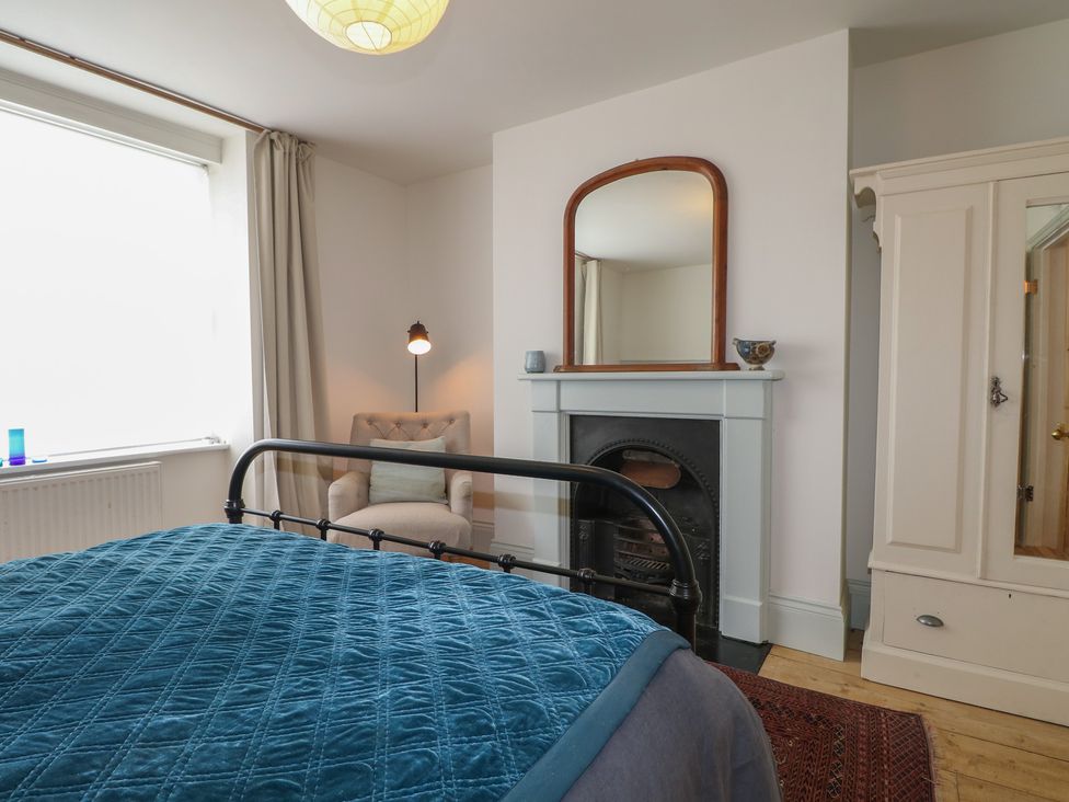 A bedroom with a bed and armchair at Lower Floor Flat
