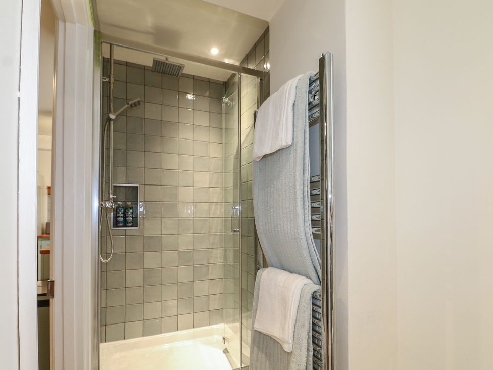 A bathroom with a shower and towel rail at Lower Floor Flat in 