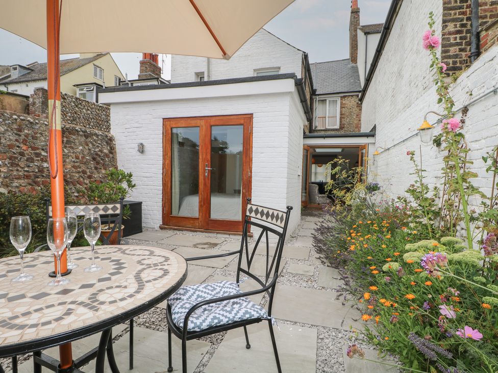 A garden with table, chairs, and door at Lower Floor Flat