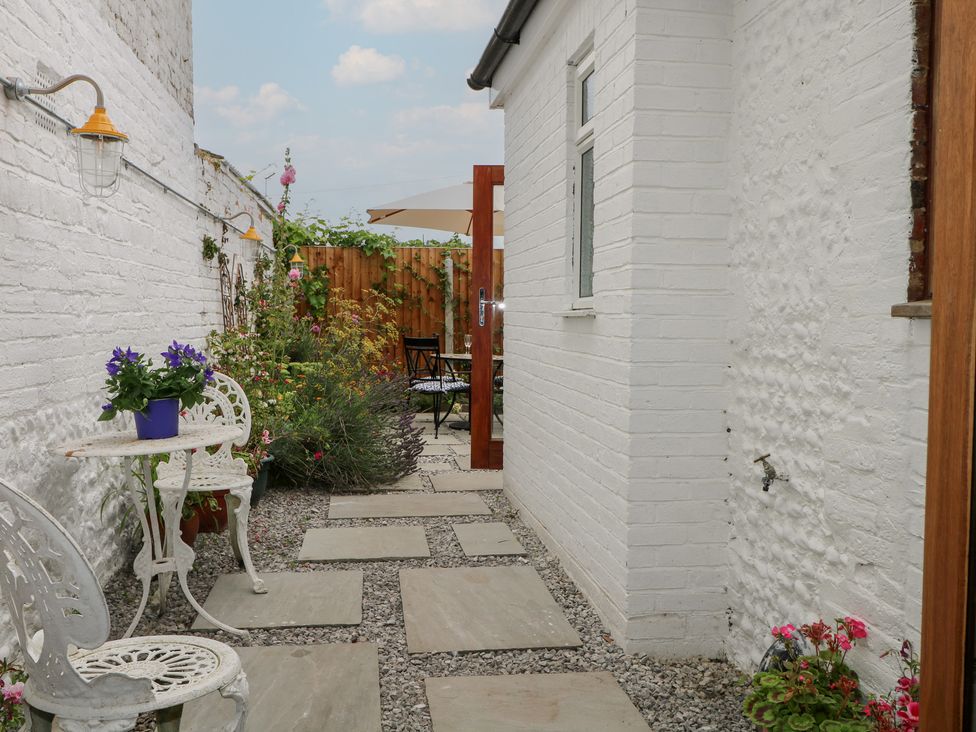 An outdoor garden with a stone pathway and a table with chairs at Lower Floor Flat