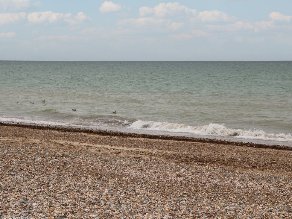 A beach with pebbles and waves at the shore