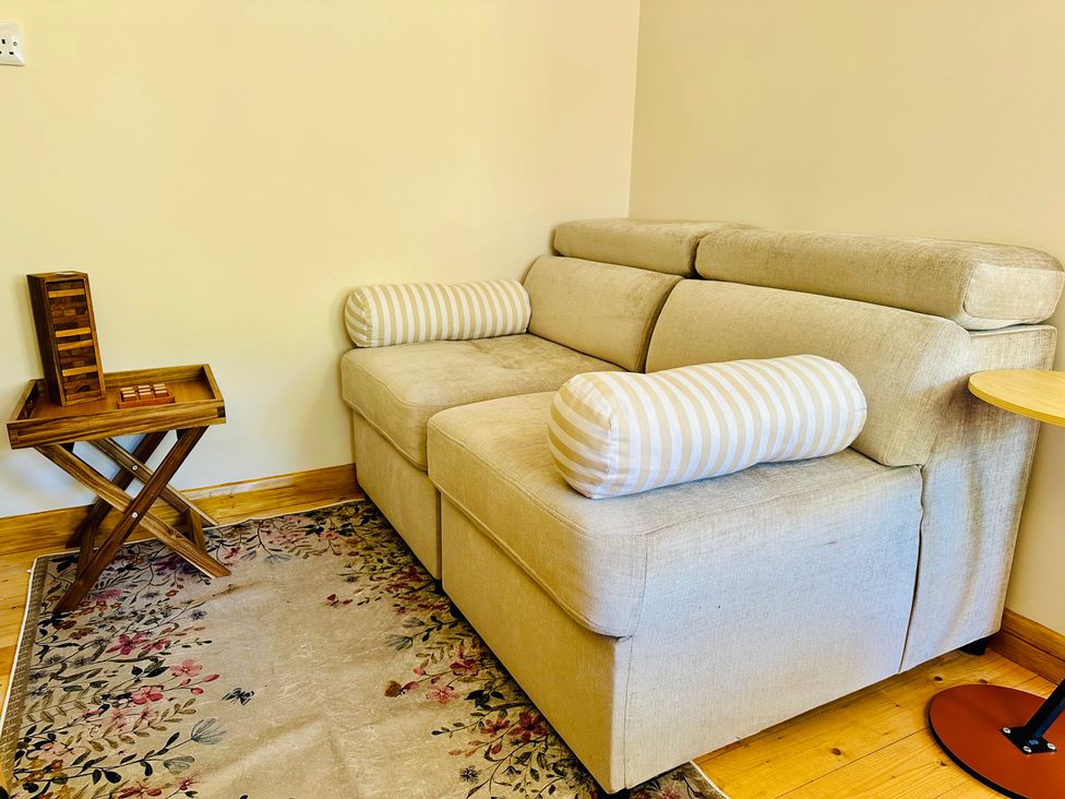 A living room with a sofa and side table at Harvey's Lodge in Helston