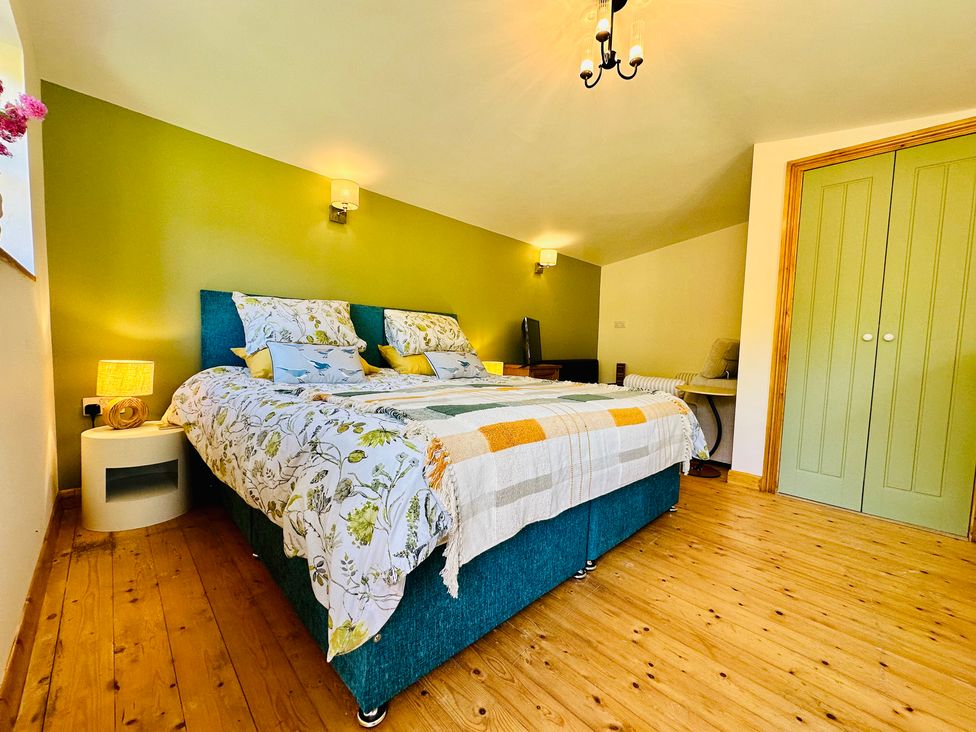 A bedroom with a bed and nightstand at Harvey's Lodge in Helston