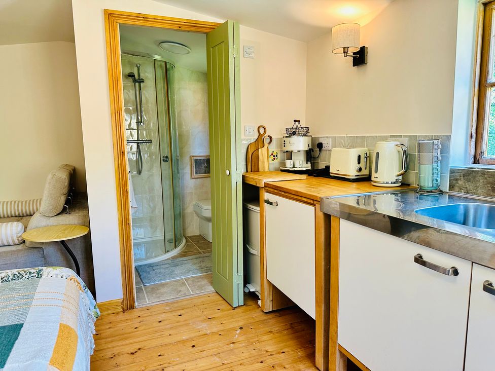 A kitchen with a shower and toilet at Harvey's Lodge in Helston