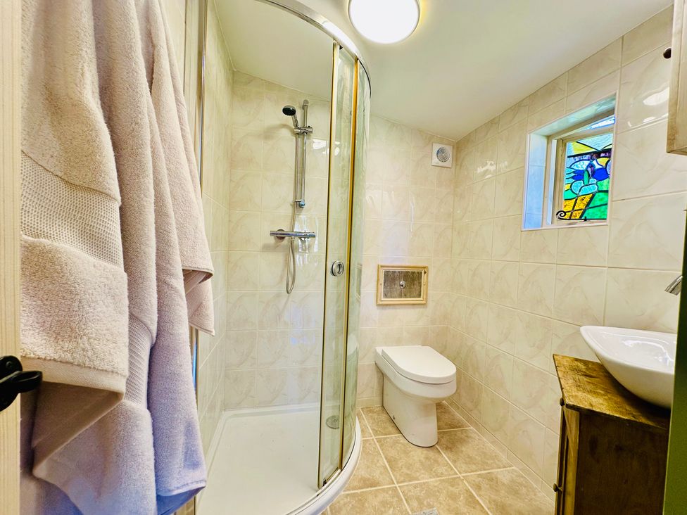 A bathroom featuring a shower, toilet, and sink at Harvey's Lodge, Helston