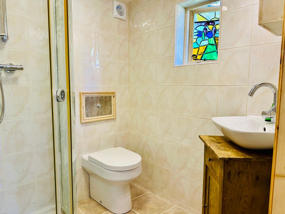 A bathroom with a shower, toilet, and sink at Harvey's Lodge in Helston