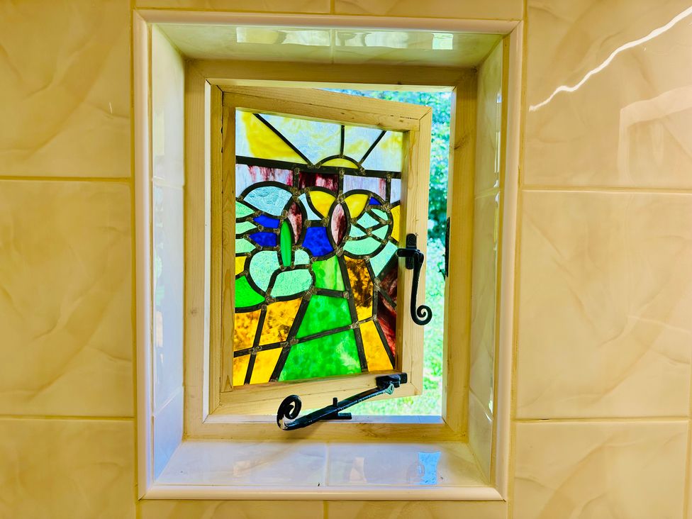 A stained glass window in a bathroom at Harvey's Lodge, Helston