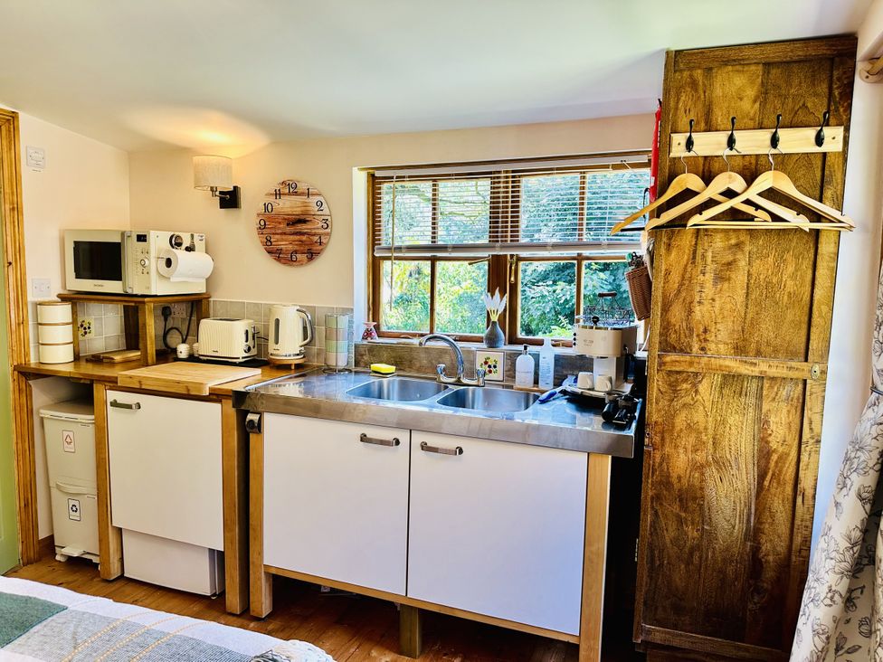 A kitchen with a sink and appliances at Harvey's Lodge in Lowertown, Helston
