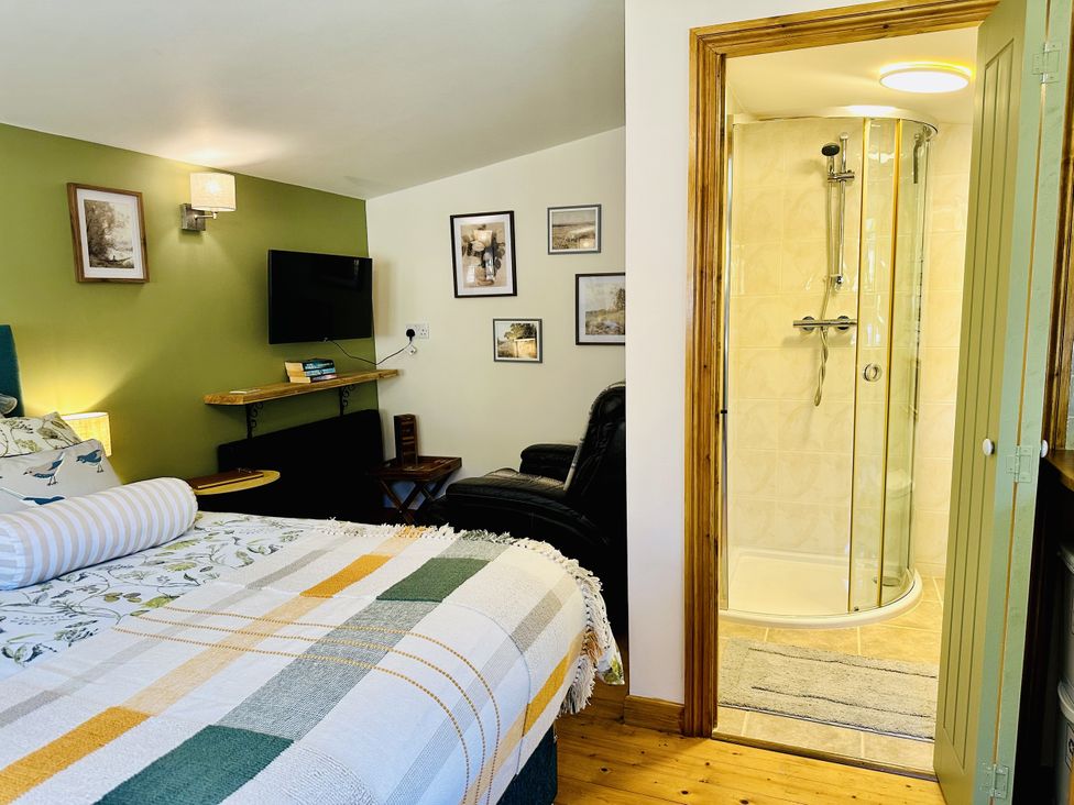 A bedroom with a shower in the corner at Harvey's Lodge in Lowertown, Helston