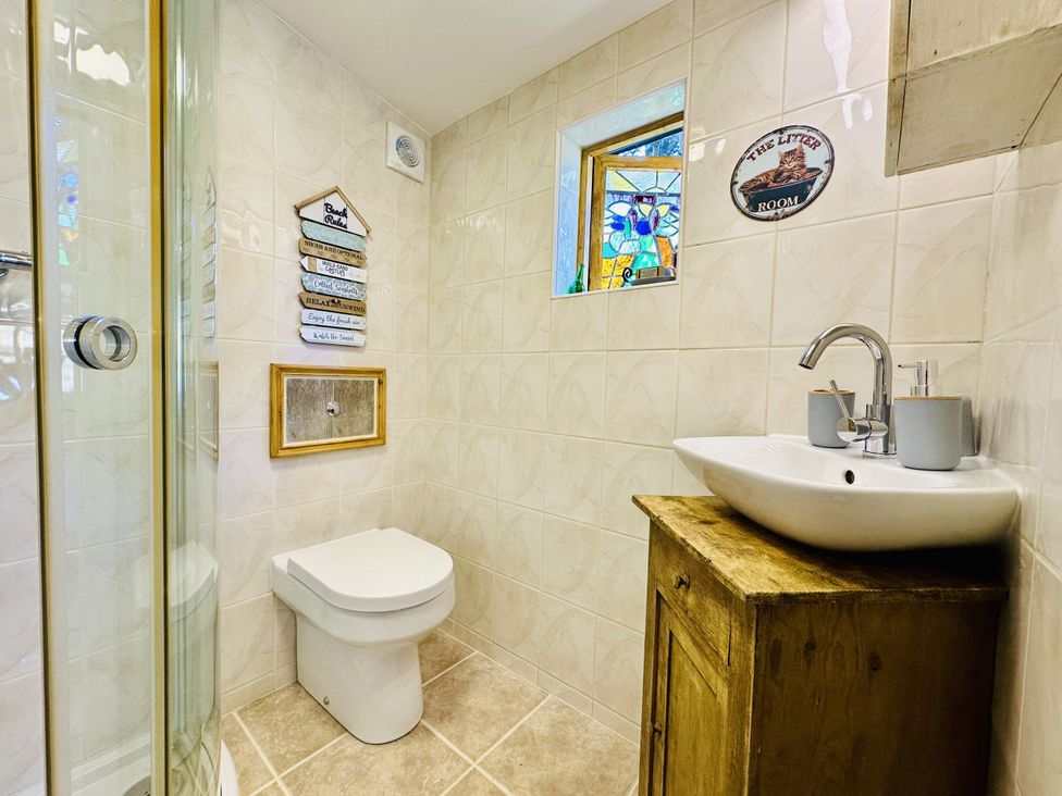 A bathroom with a shower, toilet, and sink at Harvey's Lodge in Lowertown, Helston