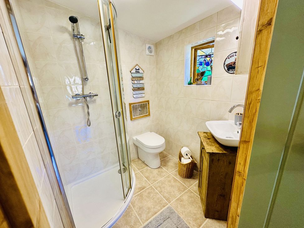 A bathroom with a shower, toilet, and sink at Harvey's Lodge, Lowertown, Helston