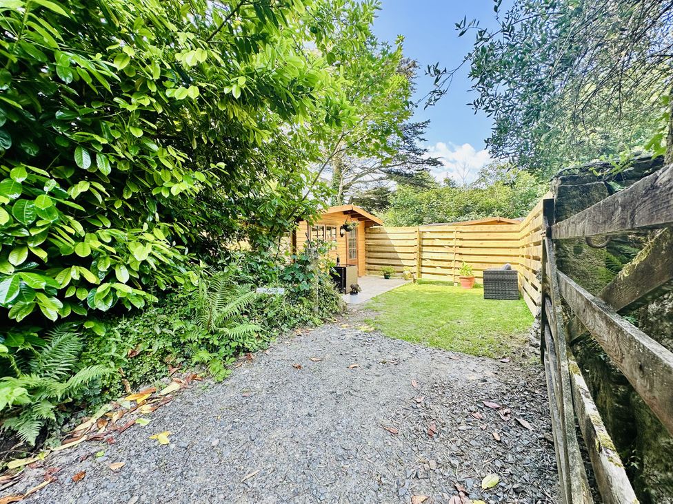 A garden with a shed and a gravel path at Harvey's Lodge in Lowertown, Helston