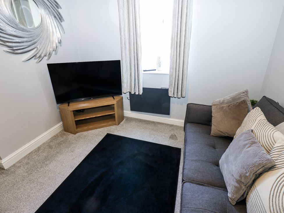 A living room with a sofa and television at Lowther House in Whitehaven