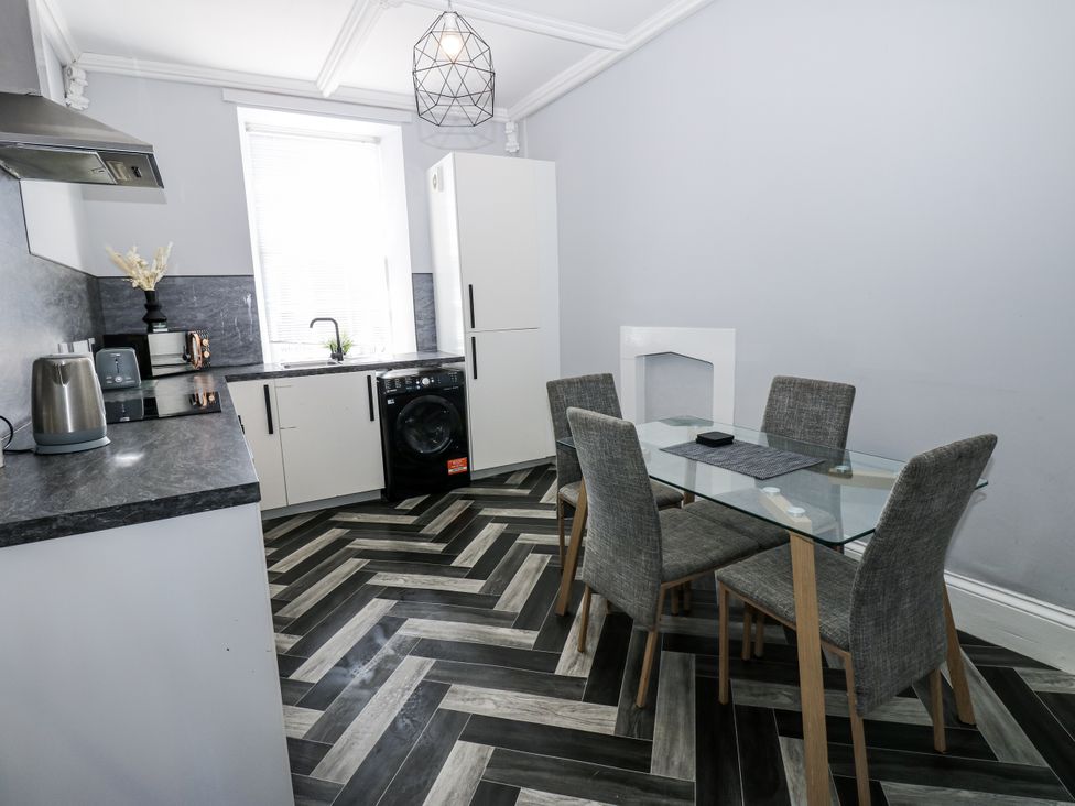 A kitchen with a dining table and appliances at Lowther House in Whitehaven