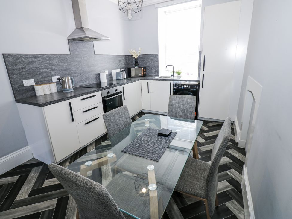 A kitchen with a table and chairs at Lowther House in Whitehaven