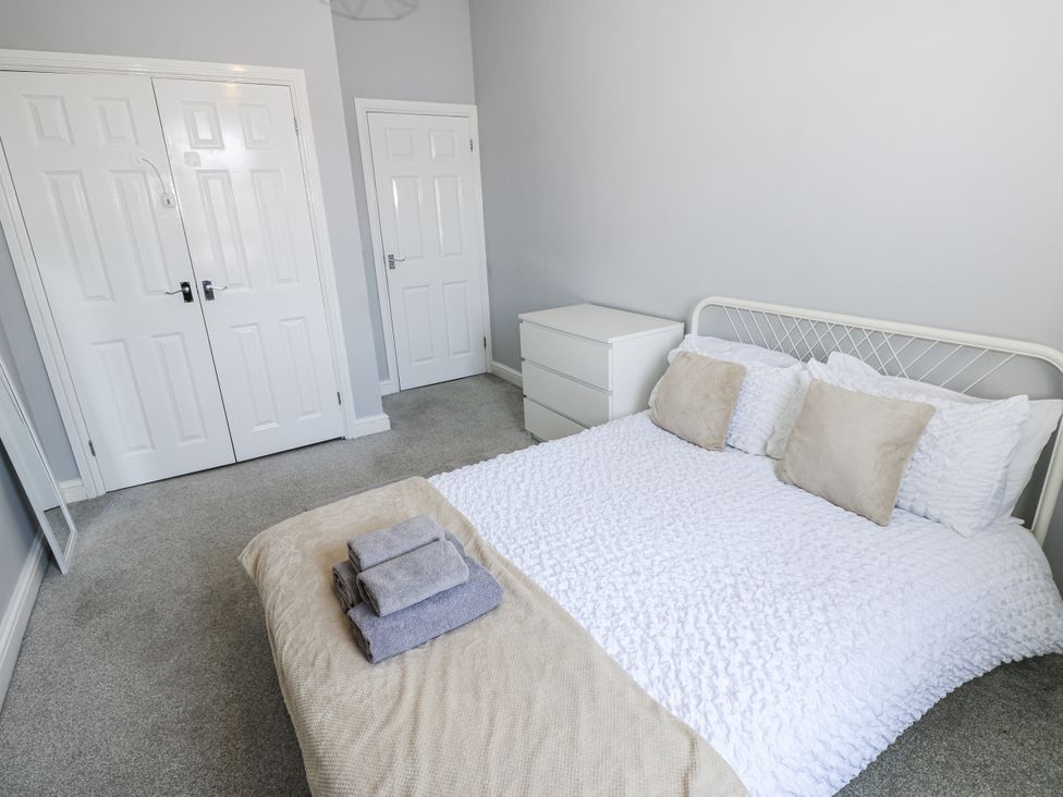 A bedroom with a bed and towels on it at Lowther House in Whitehaven
