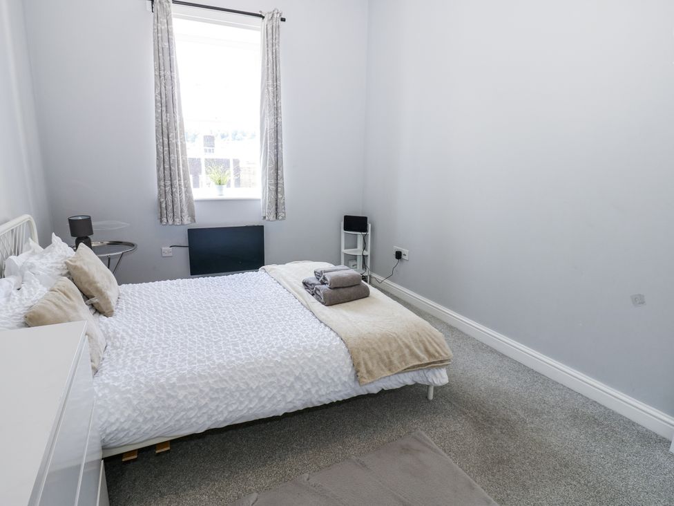 A bedroom with a bed and towels at Lowther House Whitehaven