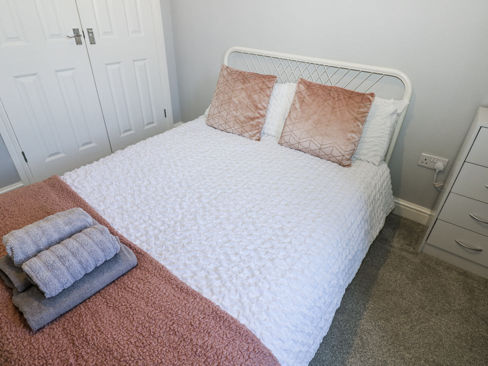A bedroom with a bed and towels at Lowther House in Whitehaven