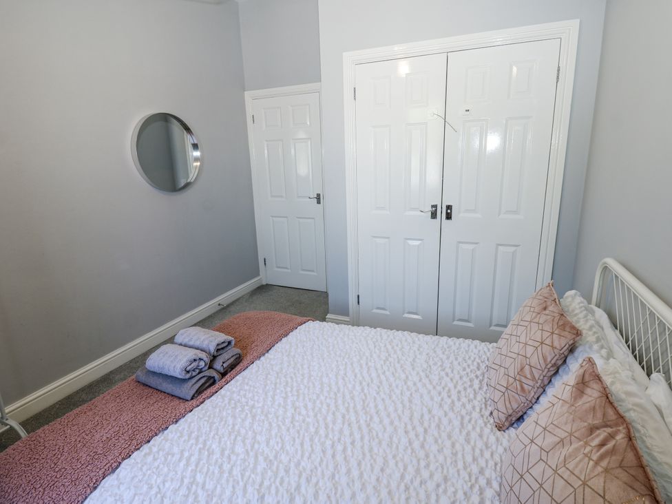 A bedroom with a bed and towels at Lowther House in Whitehaven