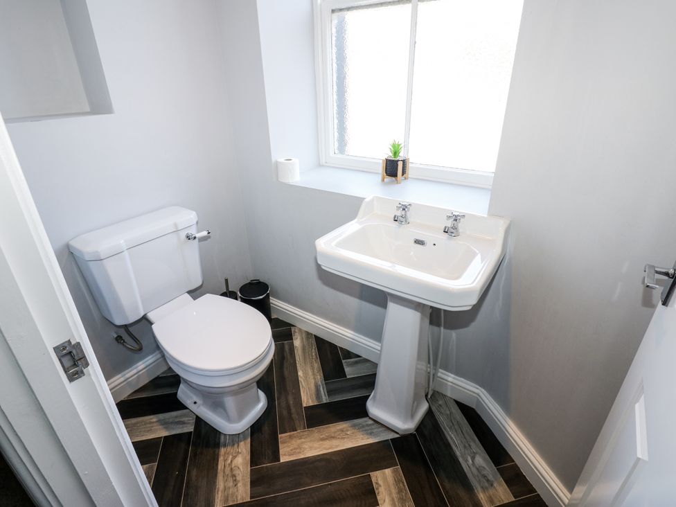 A bathroom with a toilet and sink at Lowther House in Whitehaven