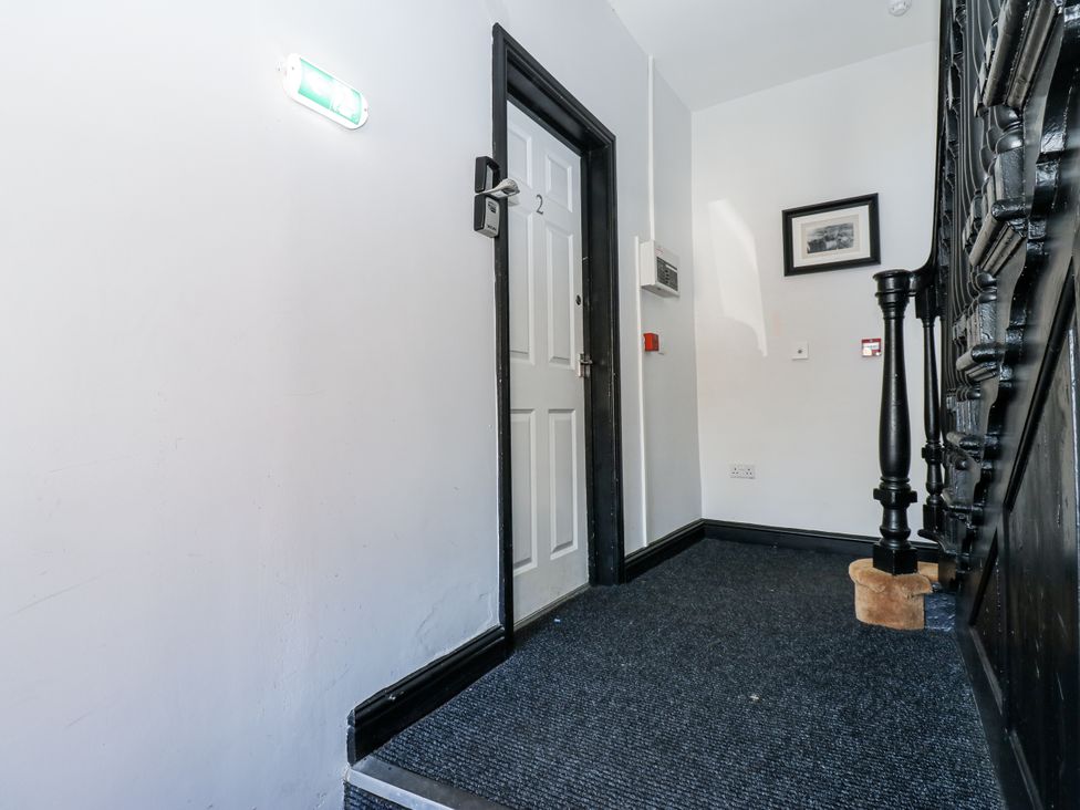 A hallway with a door and a staircase at Lowther House in Whitehaven