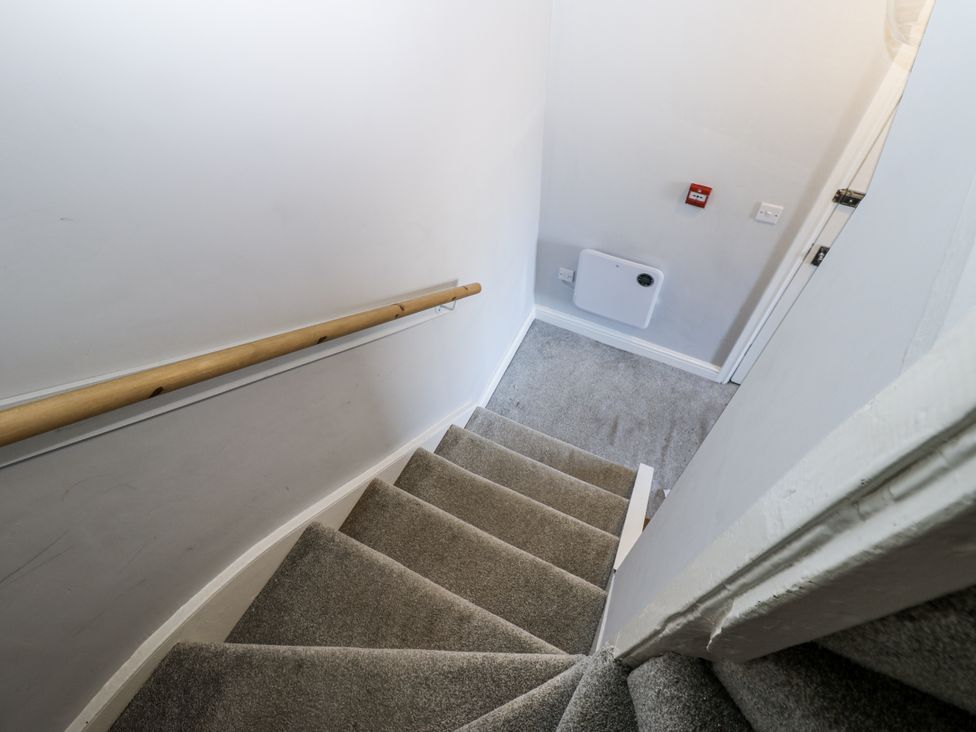 A staircase with a handrail and door at Lowther House in Whitehaven