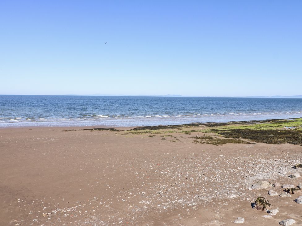 A beach with sand and seaweed at Lowther House in Whitehaven