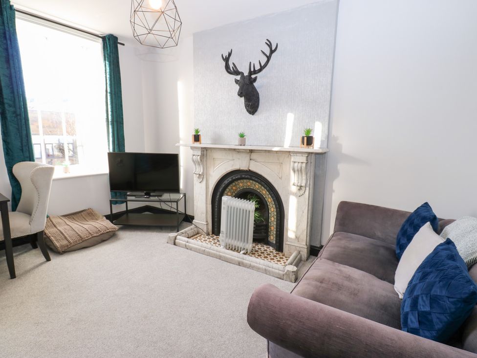 A living room with a sofa and television at Lowther Apartment in Whitehaven