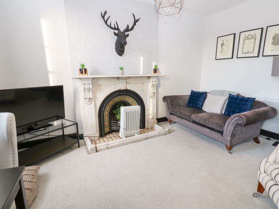 A living room with a sofa and television at Lowther Apartment in Whitehaven