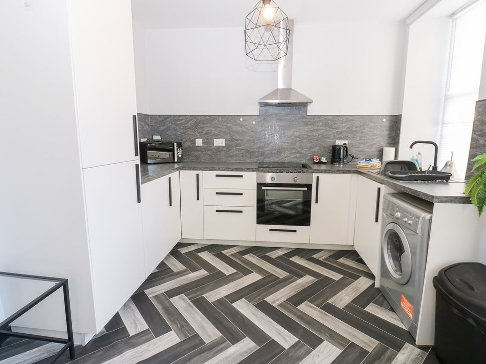 A kitchen with appliances and cabinets at Lowther Apartment in Whitehaven