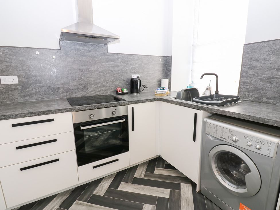 A kitchen with an oven and washing machine at Lowther Apartment in Whitehaven