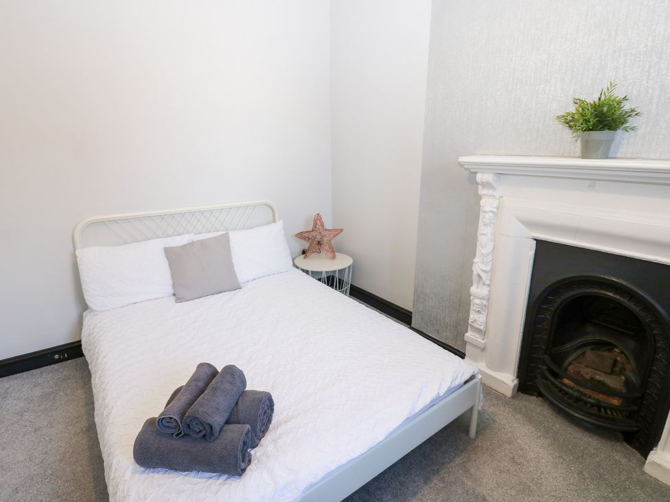 A bedroom with a bed and fireplace at Lowther Apartment in Whitehaven
