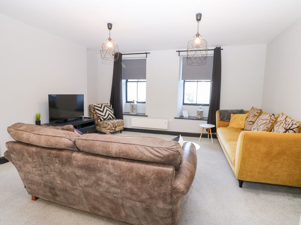 A living room with a sofa and television at Lowther Penthouse in Whitehaven