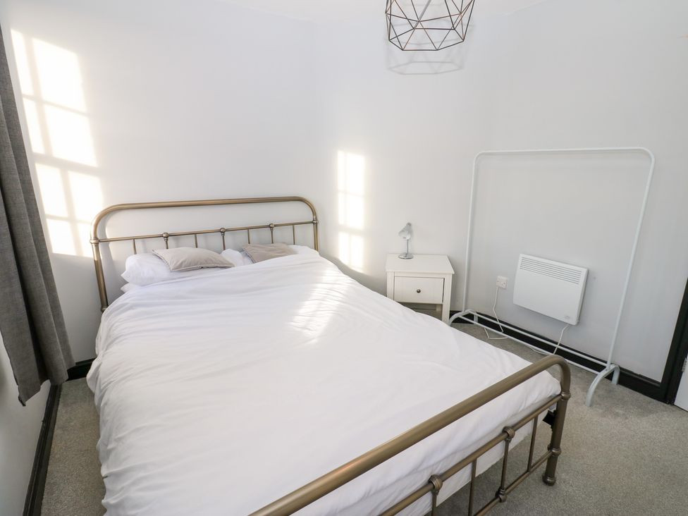 A bedroom with a bed and nightstand at Lowther Penthouse in Whitehaven