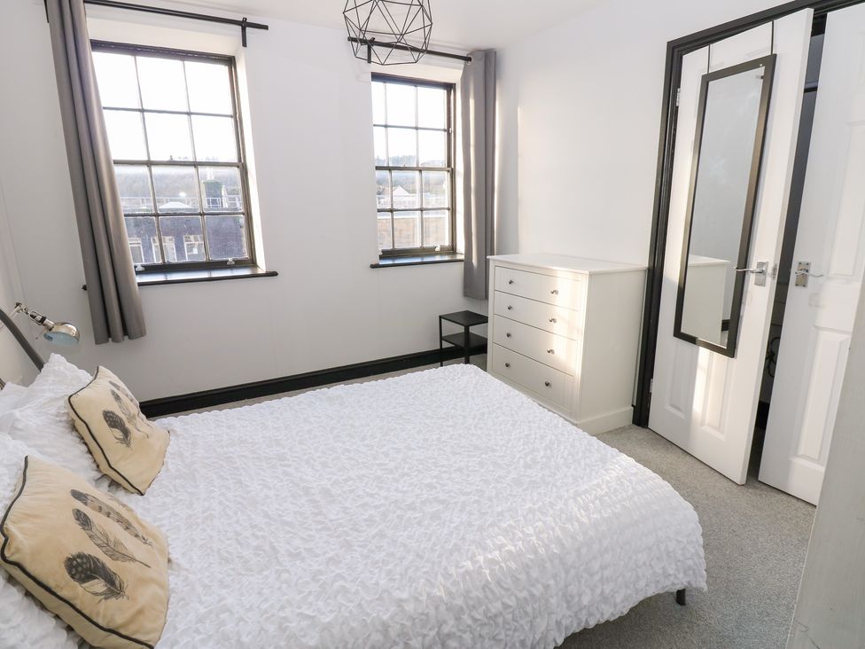 A bedroom with a bed and dresser at Lowther Penthouse in Whitehaven