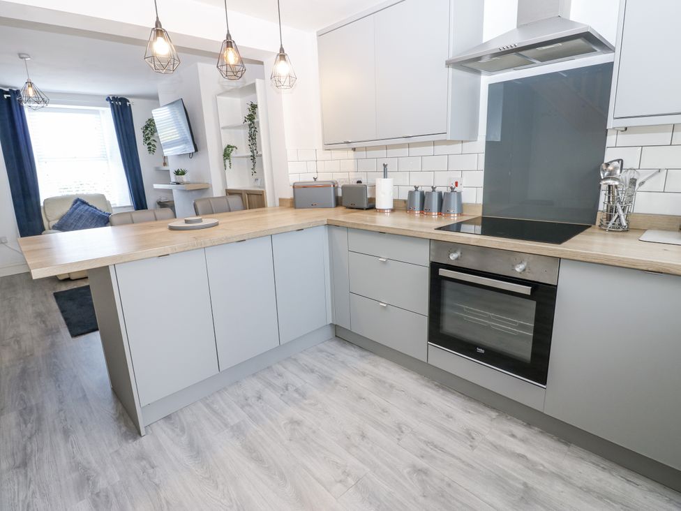 A kitchen with a countertop, oven, and sink at Keekle Terrace in Cleator Moor
