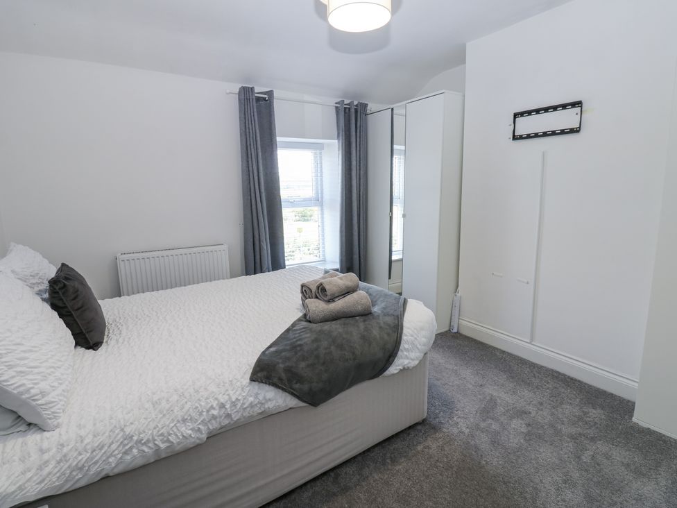 A bedroom with a bed and towels at Keekle Terrace in Cleator Moor